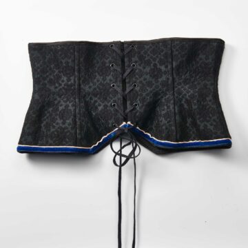 Corset noir en damassé de soie, avec des petit bouton argenté, un liseré bleu et un lacet à l'arrière